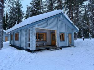 a small blue cabin with snow on the roof at Atmospheric log cabin by the ski tracks in Ylläsjärvi