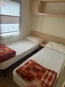 two beds in a small room with a window at Domek na Lazurowym Wybrzeżu in Gassin