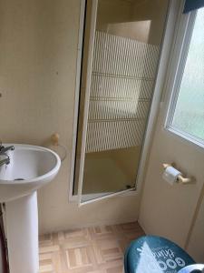a bathroom with a sink and a glass shower at Domek na Lazurowym Wybrzeżu in Gassin