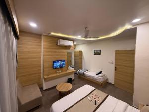 a room with a room with a tv and a couch at Hotel Krish villa in Vadodara