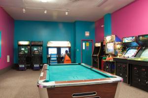una sala de juegos con mesa de billar y máquinas recreativas en Sea Pines Loft Park Model 3, en Swainton