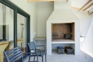 - un salon avec deux chaises et une cheminée en briques dans l'établissement De Hoop Farm - mountain view, à Breërivier