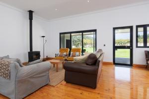 un salon avec deux canapés et une cheminée dans l'établissement De Hoop Farm - mountain view, à Breërivier