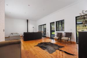 un salon avec un canapé, une table et des chaises dans l'établissement De Hoop Farm - mountain view, à Breërivier 39 autres photos