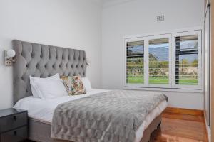 a bedroom with a large bed and a large window at De Hoop Farm - Mountain View in Breërivier