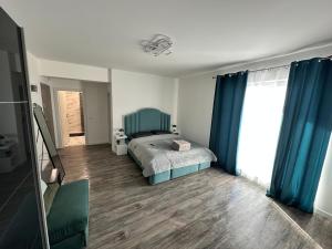a bedroom with a bed and blue curtains at Garsoniera lux in Craiova