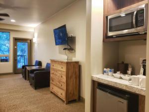 een woonkamer met een bank en een magnetron bij Driftwood Lodge in Springdale