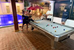 een man die pool speelt in een pooltafel bij White Elephant Hostel in Luang Prabang