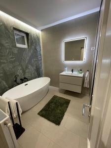 a bathroom with a white tub and a sink at Sóstó Liget House in Igricetanya +15 photos