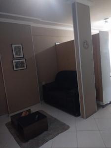 ein Wohnzimmer mit einer schwarzen Couch und einem Tisch in der Unterkunft flat confortável in Campos dos Goytacazes