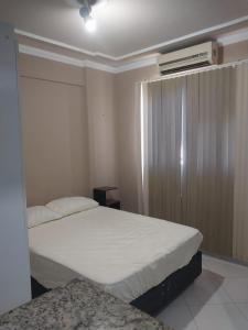 ein Schlafzimmer mit zwei Betten und einer Klimaanlage in der Unterkunft flat confortável in Campos dos Goytacazes