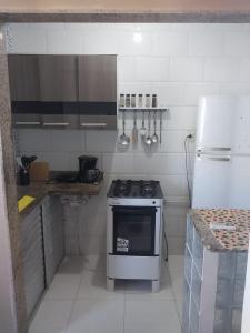 eine kleine Küche mit einem Herd und einem Kühlschrank in der Unterkunft flat confortável in Campos dos Goytacazes