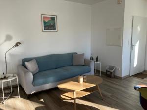 a living room with a blue couch and a table at Maison Gure Chokoa Pays Basque in Bardos