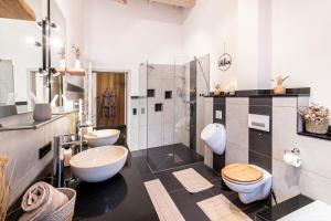 a bathroom with two sinks and a toilet and a shower at Riedbach-Lodge 3 in Viechtach +8 photos