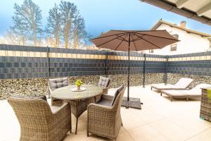 a patio with a table and chairs and an umbrella at Riedbach-Lodge 3 in Viechtach