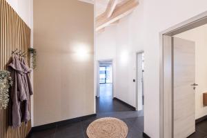 a hallway with white walls and a door and a rug at Riedbach-Lodge 3 in Viechtach