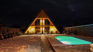 a house with a pool in front of it at night at Rancho in Ladyzhyn