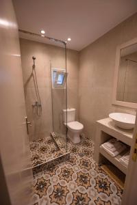 een badkamer met een douche, een toilet en een wastafel bij Vasilis Boutique Studios in Myrties
