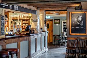 eine Bar mit Holzhockern in einem Restaurant in der Unterkunft Cub Bedroom One in Eastdean