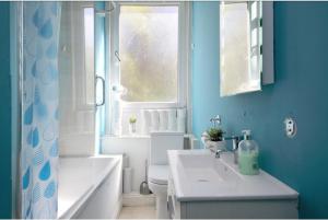 een badkamer met een wastafel en een toilet en een raam bij Edinburgh Central Drumdryan ApartHotel in Edinburgh +12 foto's