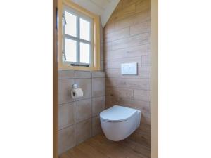 een badkamer met een toilet en een raam bij Lovely Holiday Home in Texel near Sea in Oost +16 foto's