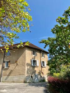 un grande edificio in mattoni con alberi di fronte di Très bel appartement en plein centre d'Arbois ad Arbois Altre 10 foto