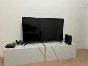 a large flat screen tv sitting on top of a table at Le cocon avec Terrasse in Amiens