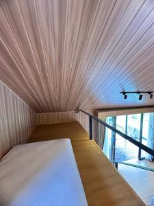 een bed in een kleine kamer met een plafond bij Sai Wana Cabin Bedugul in Bedugul