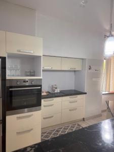 a kitchen with white cabinets and black appliances at Apartmán 6 in Spišské Podhradie