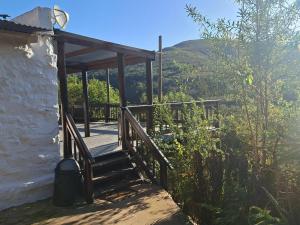 a wooden stairway leading to a house with mountains in the background at Die Skoolhuisie in Avontuur