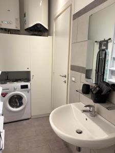 a bathroom with a sink and a washing machine at Casina al Lago in Lavena Ponte Tresa +19 photos
