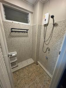 a shower in a bathroom with a window and a shower at WannaB Hostel in Khlong San