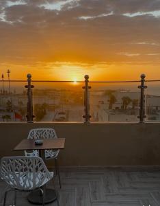 a sunset on a rooftop with a table and chairs at Hôtel Moukawama Restaurant & SPA Dakhla in Dakhla