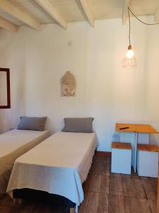 una stanza con due letti e un tavolo con una maschera sul muro di Camote Casa de Mar Tinys House a La Estafeta