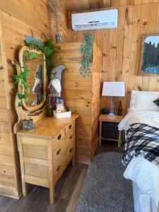 ein Schlafzimmer mit einem Bett und einer Holzwand in der Unterkunft Le Richelieu in St-Bernard de Lacolle