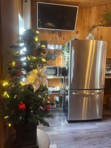 eine Küche mit einem Weihnachtsbaum und einem Kühlschrank in der Unterkunft Le Richelieu in St-Bernard de Lacolle + 1 Foto