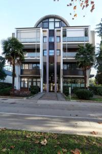 un immeuble de bureaux avec des palmiers devant lui dans l'établissement Residence Concordia, à Gorizia