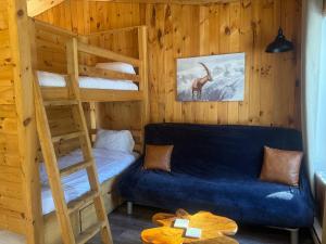 ein Schlafzimmer mit einem Etagenbett und einem blauen Sofa in der Unterkunft Le Richelieu in St-Bernard de Lacolle