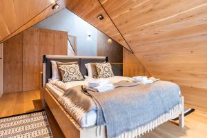 a bed in a room with wooden walls at Zacisze Gór by Apart Concept Podhale in Zakopane