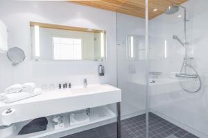 a white bathroom with a sink and a shower at Hotel Levi Panorama in Levi
