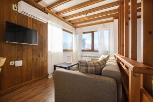 een woonkamer met een bank en een tv bij Hotel Razlog in Razlog