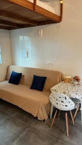 a couch with two pillows and a table in a room at Tiny House Armação no Morro in Florianópolis