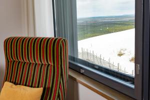 a striped chair sitting in front of a window at Hotel Levi Panorama in Levi