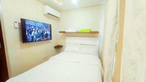 a small room with a bed and a tv on the wall at Serenity Gardens,pool retreat, Kigamboni in Dar es Salaam