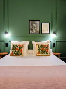 een slaapkamer met een groot bed met groene muren bij L'Ancienne Boulangerie in Chavagnes