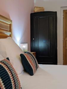 een bed met een zwart kastje en twee kussens erop bij L'Ancienne Boulangerie in Chavagnes