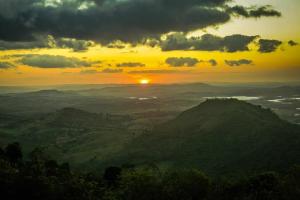 a sunset in the mountains with the sun setting at Solar de Bonito - Casa Ingá in Bonito