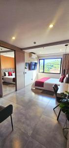 een slaapkamer met een bed en een groot raam bij Hotel Living 35 Suites Piso 8 Vip in Medellín