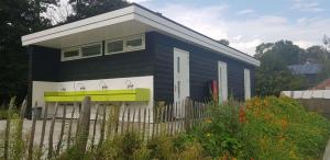 a blue and white house behind a fence at De Schamelwagen in Bant
