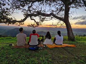 a group of people sitting on the grass watching the sunset at Solar de Bonito - Casa Ingá in Bonito